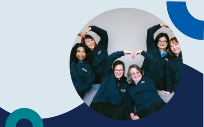 Website header graphic with a pale background and curved light blue accents, featuring a circular photo of a family of six, from a toddler to older adults, gathered together indoors and smiling towards the camera; two women wearing head scarves.