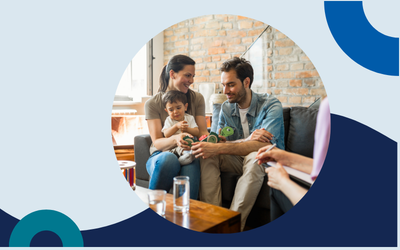 Website header graphic with a pale background and curved light blue accents, featuring a circular outdoor photo of a diverse group of adults and children gathered together and smiling, with a young person in a wheelchair in the centre of the photo.