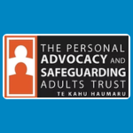 The Personal Advocacy and Safeguarding Adults Trust logo, featuring a white and an orange silhouette of a person inside an orange outlined rectangle beside the organisation’s name in white, with “Te Kahu Haumaru” underneath, on a dark grey background.