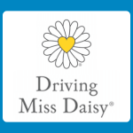 Driving Miss Daisy logo with a white daisy featuring a yellow heart centre above grey serif text reading “Driving Miss Daisy” on a white background.