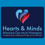 Hearts & Minds logo with a multicoloured heart-shaped graphic above blue text reading “Hearts & Minds,” smaller te reo Māori text reading “Manawa Ora me te Hinengaro,” and the tagline “Strengthening the Wellbeing of People and Communities” on a dark blue background.
