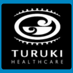 Turuki Healthcare logo, featuring a white oval Māori-style motif surrounded by a decorative curved border, above the organisation’s name in widely spaced white capital letters, on a black background.