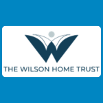 The Wilson Home Trust logo with a stylised blue W-shaped bird or wing motif above blue text reading “THE WILSON HOME TRUST” on a white background.