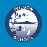 Wilson School logo with a circular blue emblem showing leaves, water, sailboats, and a distant landscape, with the words “WILSON SCHOOL” around the border.