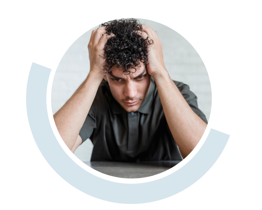 Website header graphic with curved pale blue and white accents, featuring a circular photo of a distressed-looking young man leaning forward with both hands gripping the sides of his head.