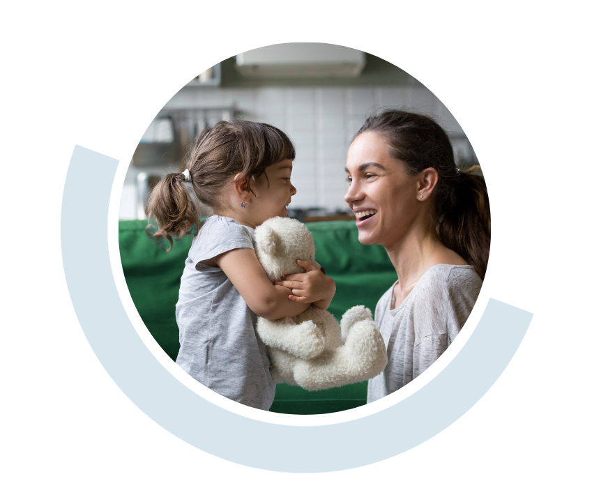 Website header graphic with a pale background and curved light blue accents, featuring a circular photo of a smiling youg girl holding a teddy beah, while lookig at a smiling young woman.